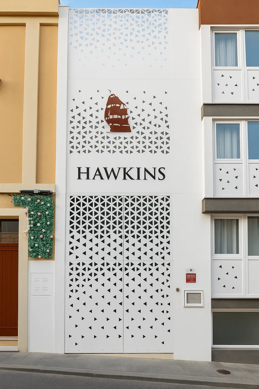Fachada de Suites Hawkins en la calle Santísimo, con celosía blanca y nombre del edificio